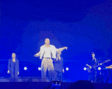 a group of people are dancing on a stage in front of a blue sky