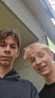 two young men standing next to each other and smiling