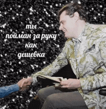 a man shakes hands with another man while holding a book ..