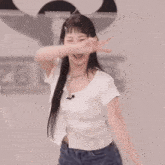 a woman in a white shirt and blue jeans is dancing in an empty room