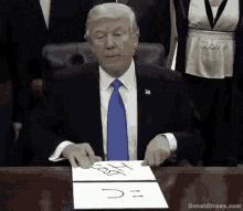 donald trump is sitting at a desk with a piece of paper that says ' lost ' on it