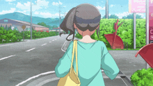 a woman in a blue shirt is walking down a street in front of a sign that says happy