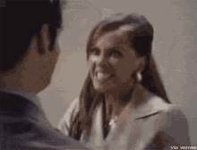 a man and a woman are standing next to each other and the woman is smiling at the man .