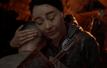 a woman holds a man 's head with arrows in her mouth