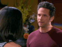 a man in a purple shirt looks at a woman