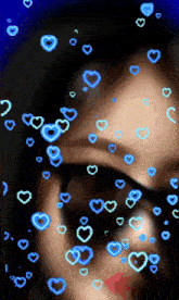 a woman wearing sunglasses is surrounded by blue hearts on a blue background