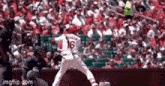 a baseball player with the number 16 on his jersey is jumping in the air during a game .