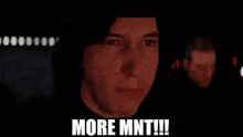 a close up of a man 's face with his mouth open and the words `` more mnt '' written on it .