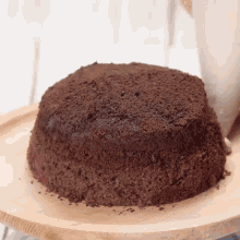 a chocolate cake is sitting on a wooden tray
