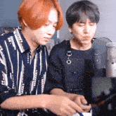 a man wearing an apron that says ' korean ' on it stands next to another man