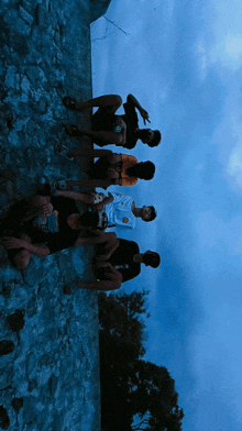 a group of young men are posing for a picture with one wearing a t-shirt that says ' a ' on it