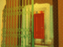 a brick wall with a red door and a green shutter