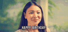 a woman is smiling and saying happy birthday !