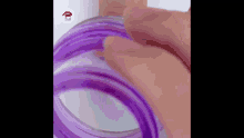 a close up of a person 's hand holding a purple jar .