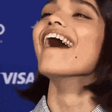a close up of a woman 's face with the word visa in the background