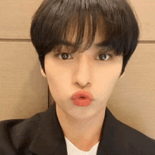 a close up of a young man making a funny face with his lips .