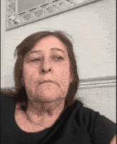 a woman in a black shirt is making a face