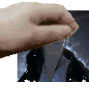 a hand is holding a piece of glass in front of a picture of a man