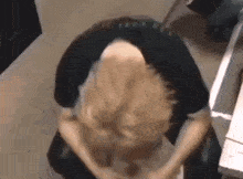 a person is sitting on the floor with their head down and their hands on their knees .