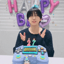 a man is celebrating his 27th birthday with a cake and balloons