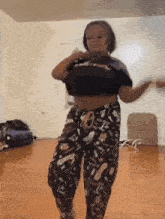 a woman is dancing in a living room while wearing pajamas .