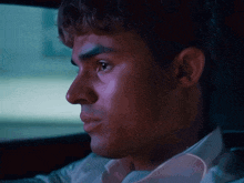 a close up of a man 's face looking out a car window