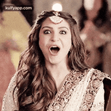 a woman is making a funny face with her mouth open and a candle on her head .
