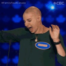 a woman with a tattoo on her head is singing into a microphone on a stage sponsored by cbc