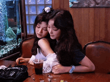 two girls hugging each other at a table with the name elsfaerie written on the table