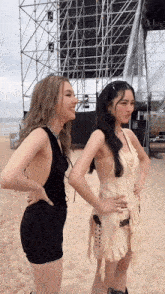 two women standing next to each other on a beach