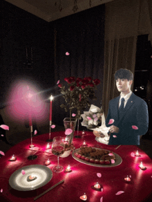a man in a suit and tie is standing at a table with candles and flowers