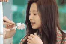 a woman is eating a piece of cake with a foreign language written on the bottom right corner