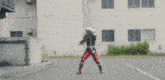 a blurry picture of a man in a superhero costume standing in front of a building