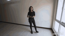 a woman is standing in an empty room with the words made in animatica on the bottom