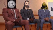 three men in suits are sitting in chairs with their hands folded in front of them