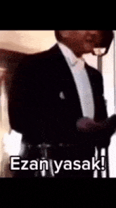 a man in a tuxedo says " ezanyasak " in white letters