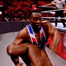 a wrestler is carrying another wrestler in a wrestling ring with the word hip on the bottom left