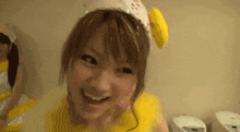 a woman is wearing a yellow dress and a white hat with a banana on it .