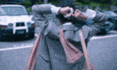 a woman adjusts her hair while walking down the street