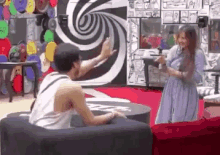 a man and a woman are dancing in a room with a swirl wall .