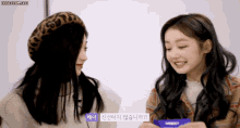 two girls are sitting next to each other and one of them is wearing a leopard print headband