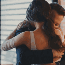 a man and woman are hugging each other and the woman is wearing a white bra
