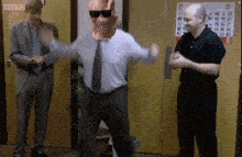 a man in a suit and tie is dancing in front of a yellow door .
