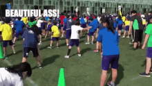 a group of people are dancing on a field with the words beautiful ass written on the bottom