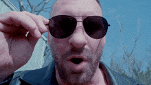 a man with a beard wearing sunglasses and a black leather jacket