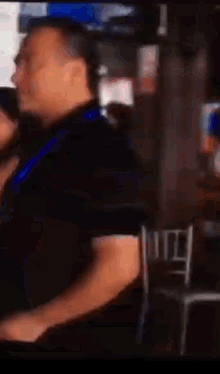 a man in a black shirt is standing in front of a pepsi advertisement