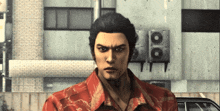 a man in a red and gold shirt stands in front of a building