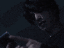a close up of a person using a cell phone in the dark .