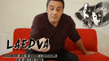 a man sitting on a red couch with the word laedva on the bottom right