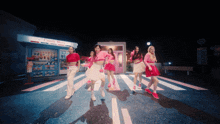 a group of girls are dancing in front of a store that says candy store